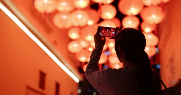 Woman Take Photo on Cellphone with Red Lantern