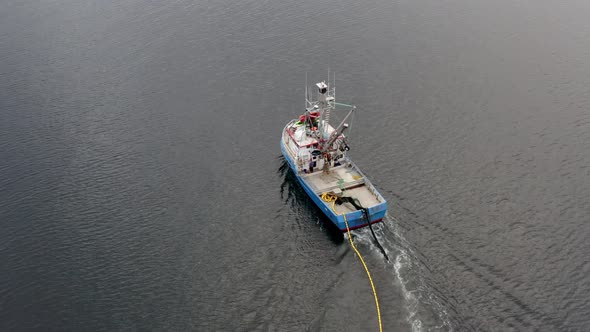 Aerial View of Fishing Trawler Boat Dropping Net in Sea. Traditional Commericial Fishing in Alaska U