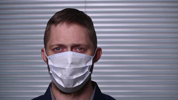 A young Caucasian man in mask are staying safe in the coronavirus epidemic