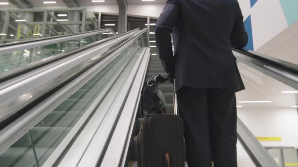 Business Man With Suitcase On Escalator