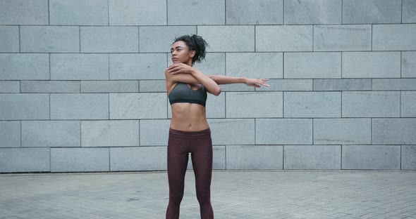 AfricanAmerican Lady Does Sports Exercises for Arms in Gym