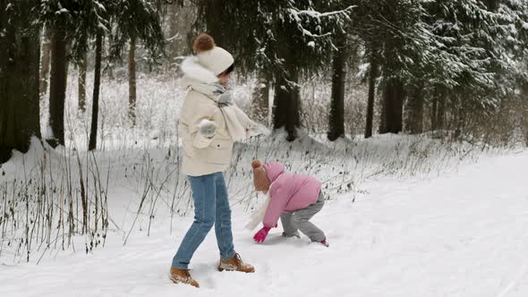 Mom and Daughter Playing Snowballs