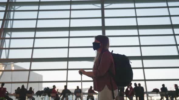 Woman in a mask waiting for her flight