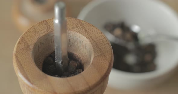 Filling a pepper grinder with peppercorns