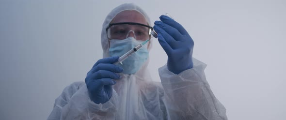 Woman extracting fluid from bottle with syringe slow motion