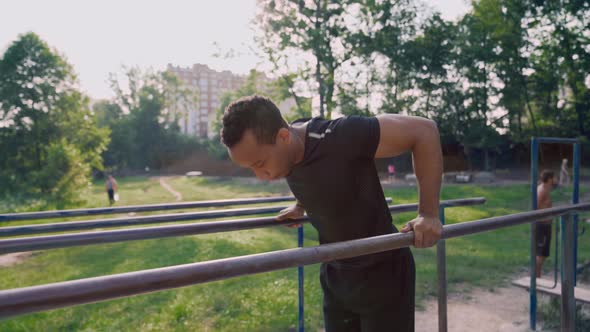 Side View of Muscular African Man Training on Parallel Bars