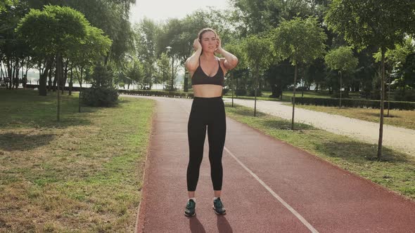 Young Active Sporty Athlete Smiling Woman is Taking a Break After Making Running and Jogging Workout