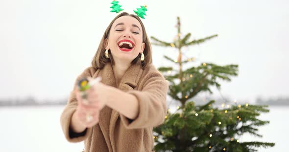 Woman Celebrating New Year Having Fun Shooting Confetti Outdoors