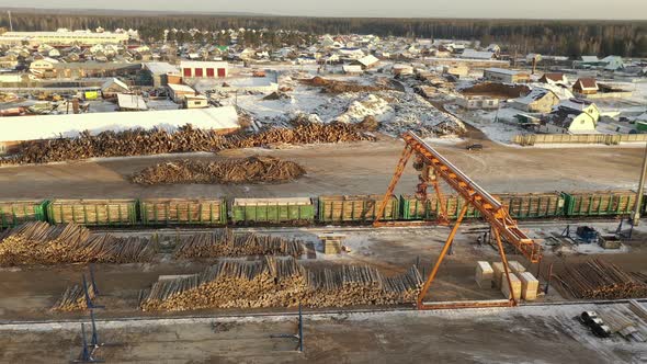 A Large Sawmill Located in Village Aerial View. Modern Woodworking Factory with a Railway Junction