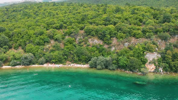 Aerial (drone) truck shot from left to right of Macedonian shore in Ohrid Lake, Pesztani and Trpejca