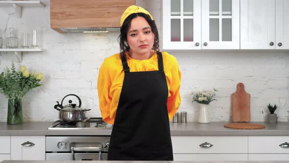 Portrait Tired Woman in Home Kitchen Takes Off Black Apron After Cooking Food