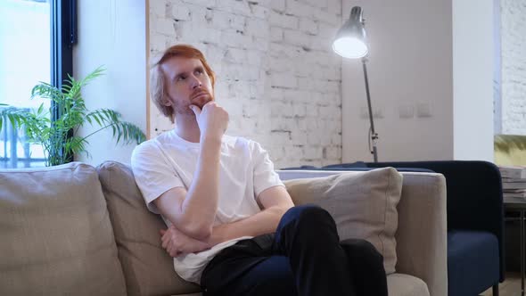 Penisve Casually Sitting Redhead Designer Thinking in Office