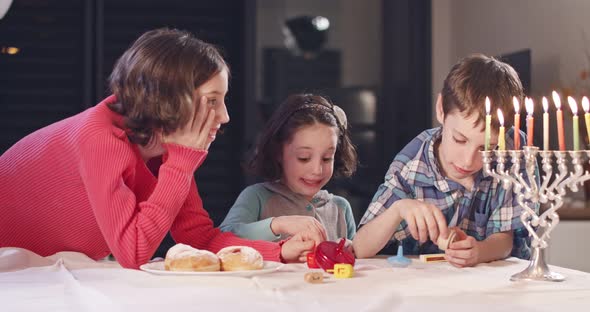 Kids playing with dreidels during Hanukka at home