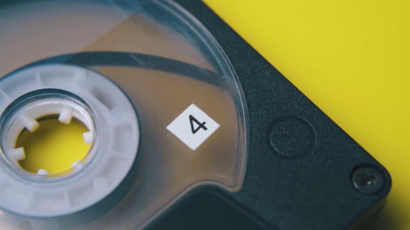 Motion Above Compact Cassette on Bright Yellow Background