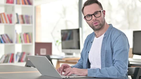 Surprised Young Man Looking at Camera at Work