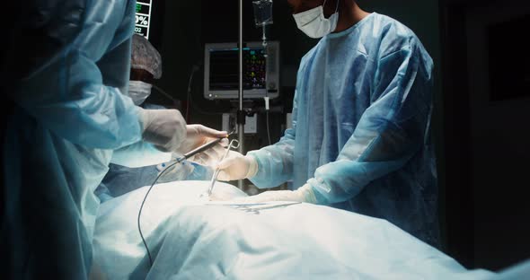 A Team of Surgeons Perform an Operation in a Bright Operating Room