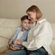 Adult Woman Sits with a Teenager on the Couch Chatting and Hugging - VideoHive Item for Sale