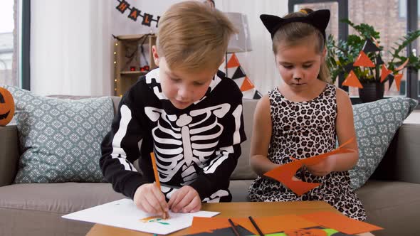 Kids in Halloween Costumes Doing Crafts at Home