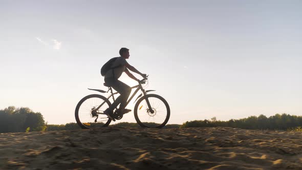 Teenage Boy Rides Bike in City Park at Sunny Day. Healthy Lifestyle Concept