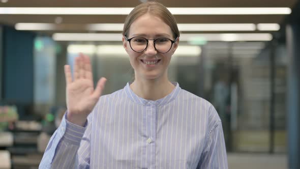 Portrait of Young Woman Waving Welcoming