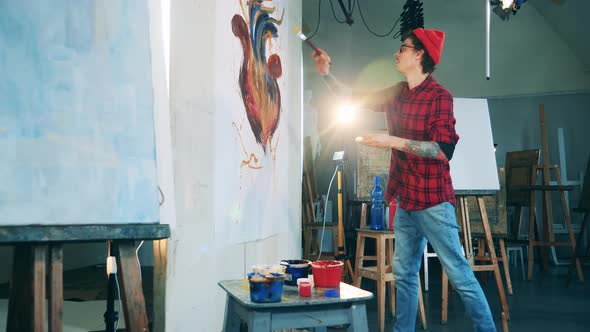 Art Studio with a Young Man Painting on a Massive Canvas