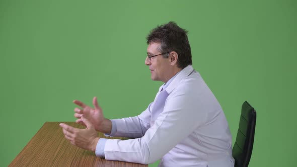 Mature Handsome Man Doctor Against Green Background