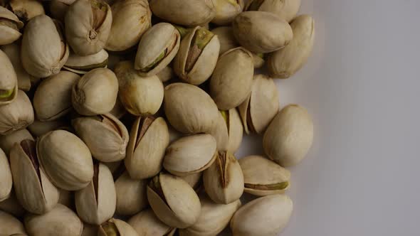 Cinematic, rotating shot of pistachios on a white surface - PISTACHIOS 029