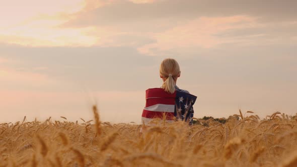 Farmer with Usa Flag on His Shoulders Stands in a Vast Field of Ripe Wheat