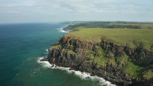 Aerial panorama of rocky coastline with green meadows, Indian Ocean