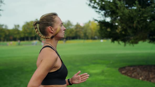 Concentrated Fit Woman Running Fast in Park, Female Runner Training in Morning