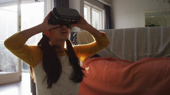 Happy asian girl at home, sitting on floor in living room using vr headset