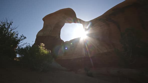 Sun shining through Metate Arch in Escalante