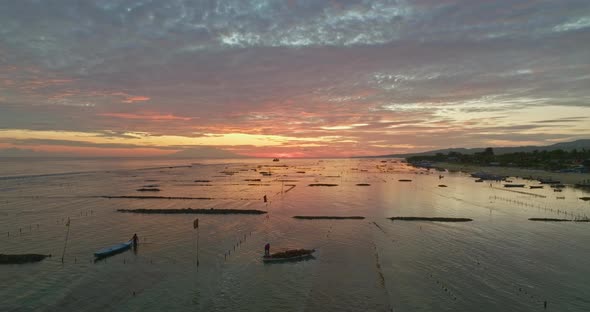 Seaweed farmers at work during sunrise at Nusa Lembongan, aerial