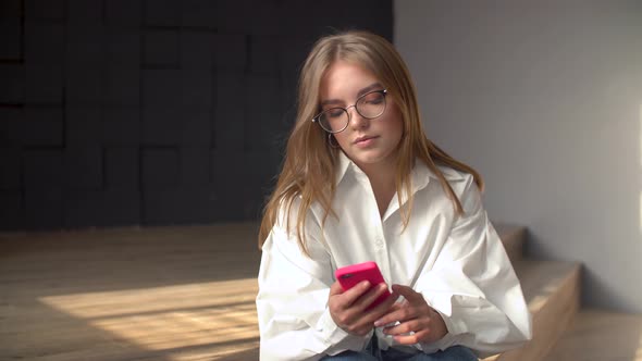 Young Woman Using Smartphone in a Livingroom