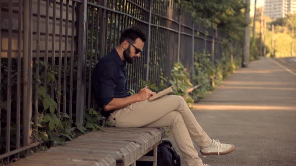 Man Reading Book On Train Station. Tourist Reading Book When Waiting Train On Electric Train Station