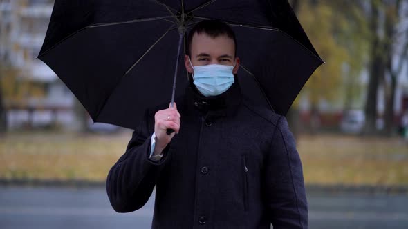 Portrait of a Frustrated Man in a Urban Street Complaining About Bad Weather in a Rainy Day During