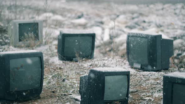 Snow Is Falling on Wasted TVs at the Garbage Dump