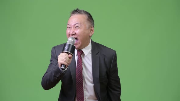 Mature Japanese Businessman Using Microphone