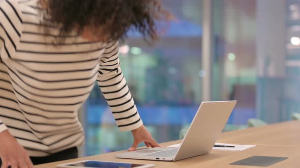 Young African Woman Coming and Starting Work on Laptop