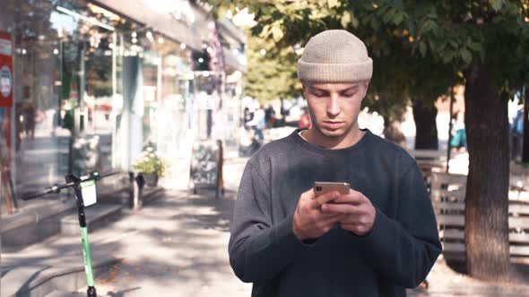 Handsome Caucasian Man Using Mobile Phone. Young Man Texting Messages, Chatting on His Smartphone