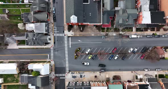 Tracking shot of white car driving through urban American city. USA flag and spring trees, rooftop c