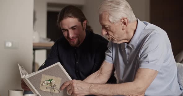 Father and Son Examining Photos Together