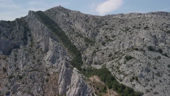 Fantastic Aerial View of a Mountain Range with a Narrow Strip of Trees