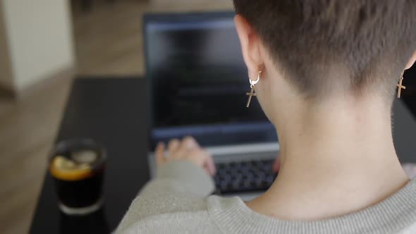 A Girl Works on a Laptop in a Cafe