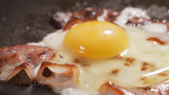 Full English Breakfast Served in a Pan. Fried Eggs, Crispy Bacon. Placed on Stone Background. Top