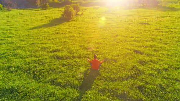 Low Altitude Radial Flight Over Sport Yoga Man at Perfect Green Grass