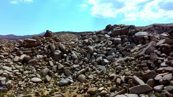 Drone shot panning left of Boulder Gardens in Pioneertown, California.