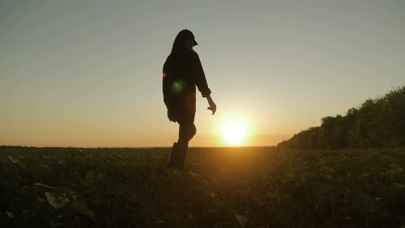 Farmer Girl Walking Beside Green Wheat Field Enjoying the Sun