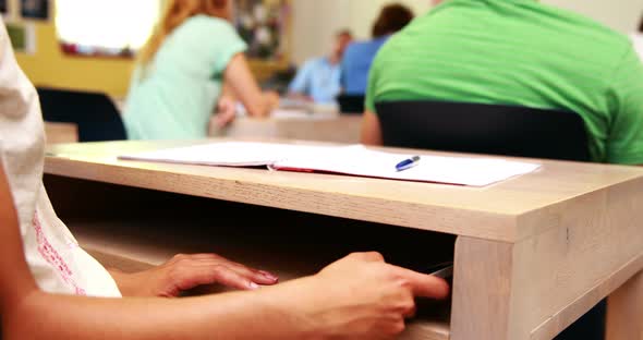 Student Using Smartphone Under the Desk in Class