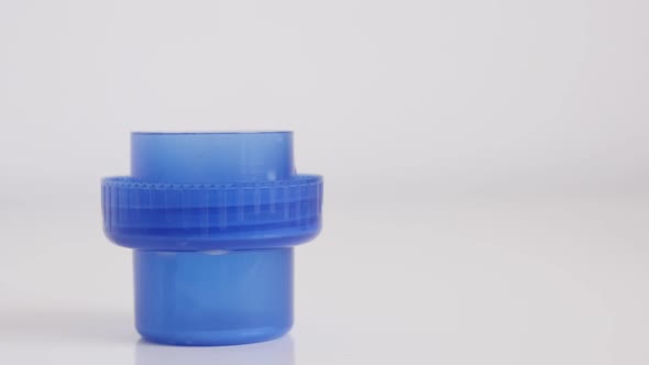 Fabric softener pouring to blue container cap slow motion footage alt